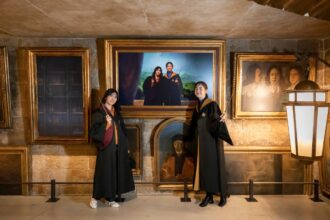 People posing beside moving portrait displays at Warner Bros. Studios Japan